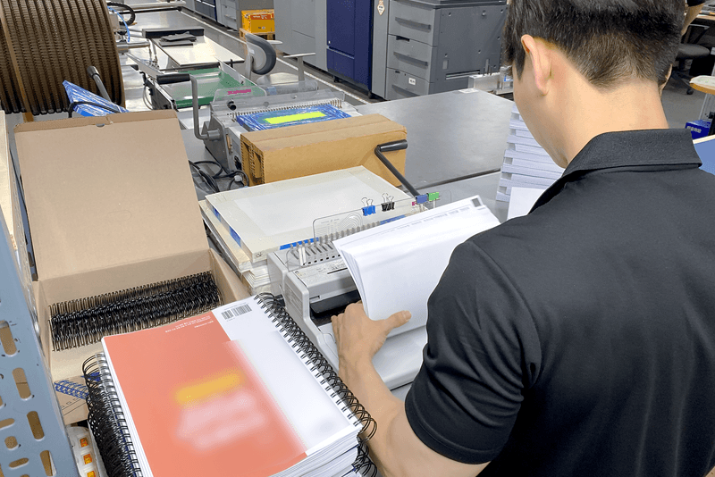 3_it보안_9_킨코스 직원이 제본 작업을 진행하는 모습, 제작 전 과정에서 보안이 유지되는 기밀 인쇄물 관리