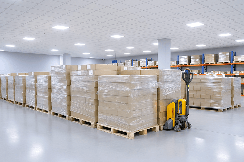 2_포장배송_13_킨코스 물류 창고 내부, 팔레트 위에 포장된 납품 박스들이 정렬되어 있는 모습, 전국 배송을 위한 출고 대기 구역