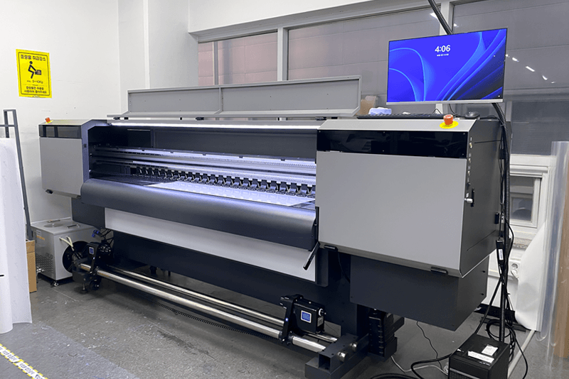 1_생산제작_14_킨코스 생산센터 내 최신 UV 잉크젯 프린터 장비가 가동 중인 모습, 대형 인쇄물 제작과 고품질 그래픽 출력에 활용되는 설비
