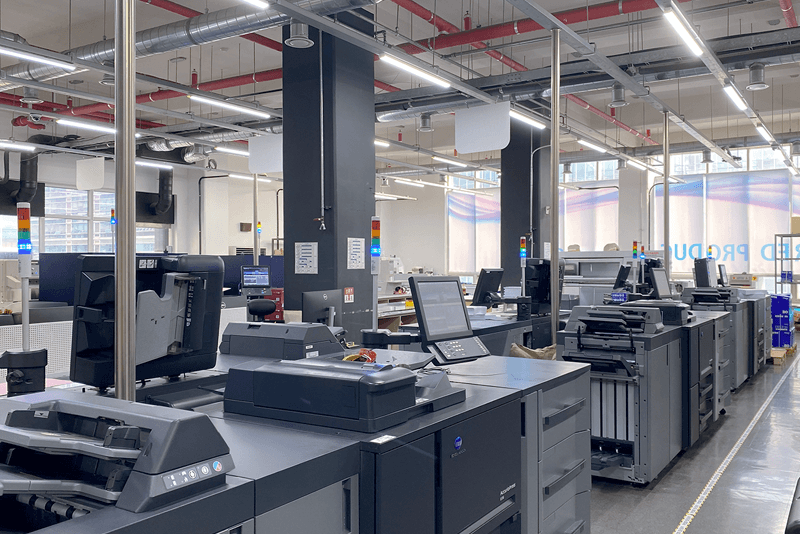 킨코스 생산센터 내부의 디지털 인쇄 장비가 정렬된 모습, 효율적 공정과 품질 일관성을 위한 스마트 인쇄 라인