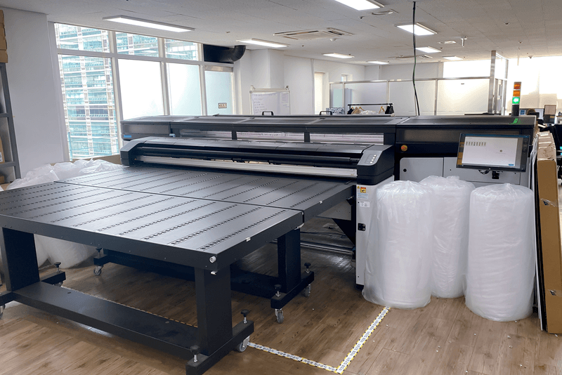 킨코스 서포트 센터 공간 내부 전경, 출력 및 제본 장비가 정돈된 상태로 배치된 인하우스형 제작실