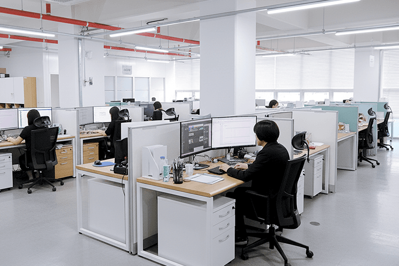 4_인력지원_12_킨코스 사무실 전경, 각 부서 직원들이 개별 모니터에서 업무를 수행하는 오피스 환경